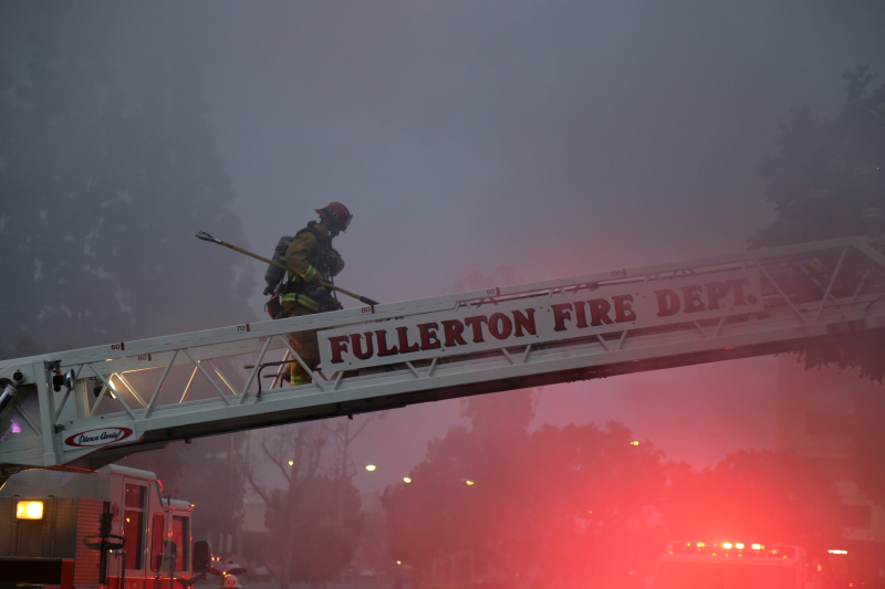 a firefighter climbs a horizontal ladder on a fire truck