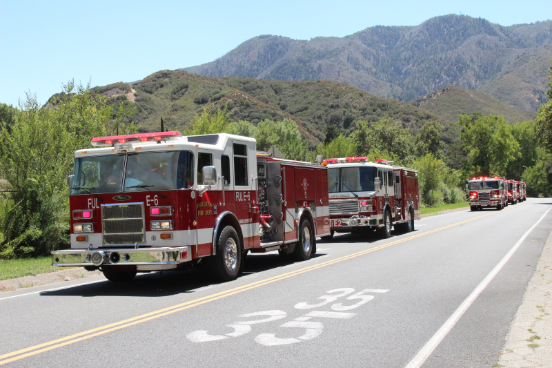 fire engines with sirens travel on a road